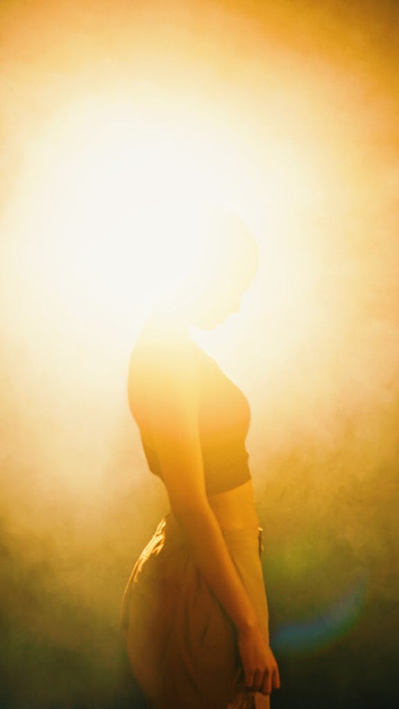 Artistic silhouette of a woman enveloped in warm, glowing light for a dreamy effect.